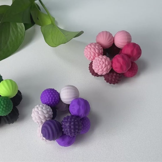 Magnetic silicone sensory balls being stacked and rolled