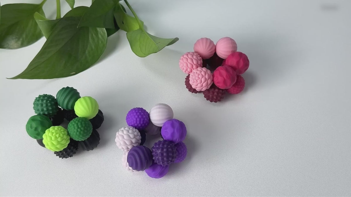 Magnetic silicone sensory balls being stacked and rolled